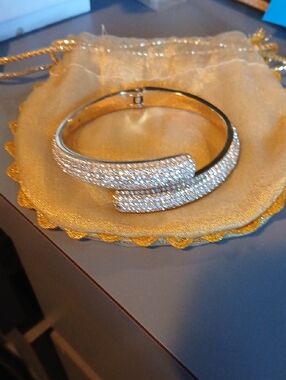 Michael Kors gold-tone hinged bypass bangle bracelet decorated with crystals. 